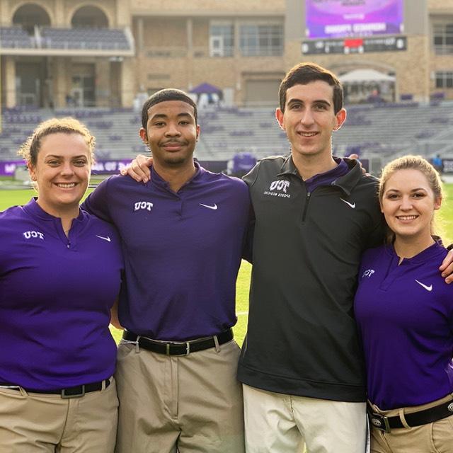 A group of athletic training students standing on the football field